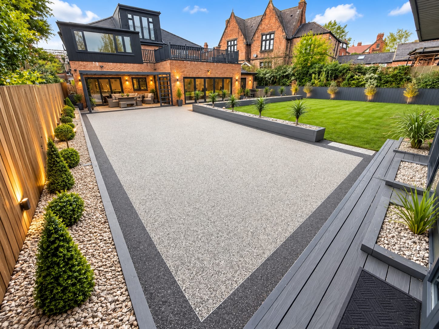 Silver resin patio with planting and warm garden lighting
